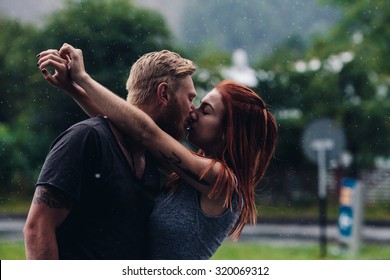 Beautiful Couple Kissing Outside In The Rain