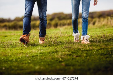 Beautiful couple in love in jeans and boots  walking around the field - Shutterstock ID 674017294
