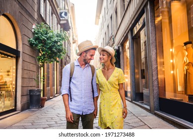 Beautiful couple of lovers shopping in the city centre - Playful tourists visiting a famous european city