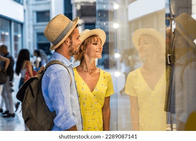 Beautiful couple of lovers shopping in the city centre - Playful tourists visiting a famous european city