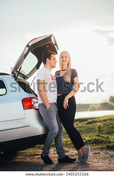 beautiful couple near the\
car at sunset