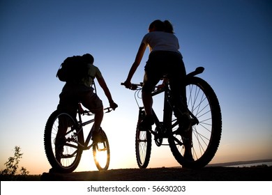 Beautiful Couple on bicycles on the brink of a rock and look afar from rock breakage - Powered by Shutterstock