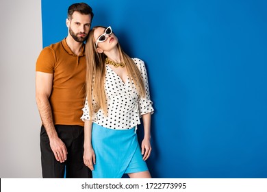 beautiful couple posing in summer clothes and sunglasses on grey and blue