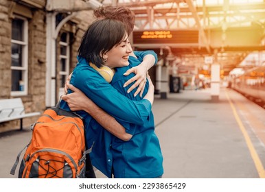 Beautiful couple at the railway station hugging, meeting and waiting for the train.