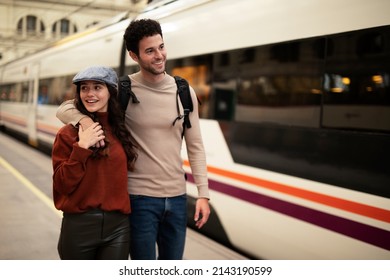 Beautiful couple at railway station waiting for the train. Young woman and man waiting to board a train