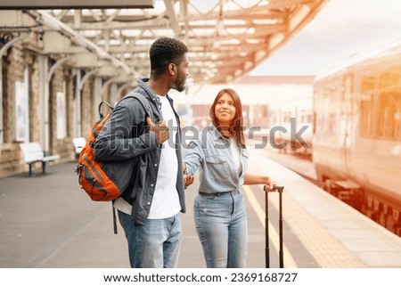 Beautiful couple at railway station waiting for the train.   Travel concept