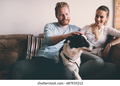 Beautiful Couple Relaxing At Home And Loving Their Dog