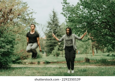 Beautiful couple rope jumping in the park on the grass - Powered by Shutterstock