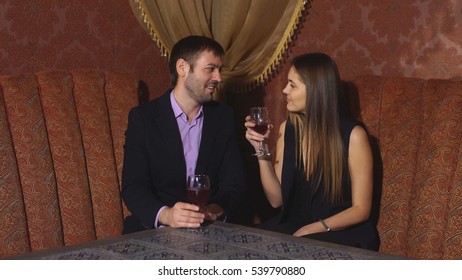 beautiful couple sitting in a fancy restaurant and talking