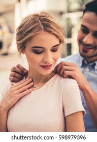 Beautiful Couple Is Smiling While Choosing Jewelry In The Shopping Mall