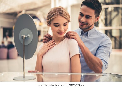 Beautiful Couple Is Smiling While Choosing Jewelry In The Shopping Mall