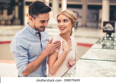 Beautiful Couple Is Smiling While Choosing Jewelry In The Shopping Mall