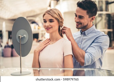 Beautiful Couple Is Smiling While Choosing Jewelry In The Shopping Mall