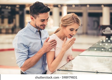 Beautiful Couple Is Smiling While Choosing Jewelry In The Shopping Mall