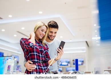 Beautiful Couple In A Tech Store, Exploring New Smart Phone.