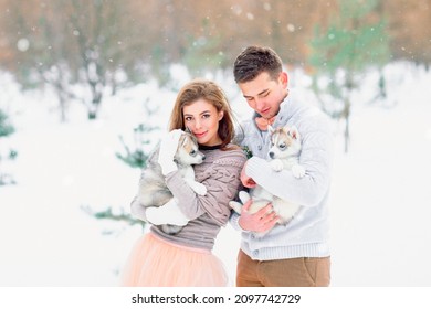 Beautiful couple walking a puppy in the winter in the Park. A young family.