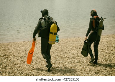 Beautiful Couple Wearing Diving Suit Is Enjoying In The Water. Retro Style.