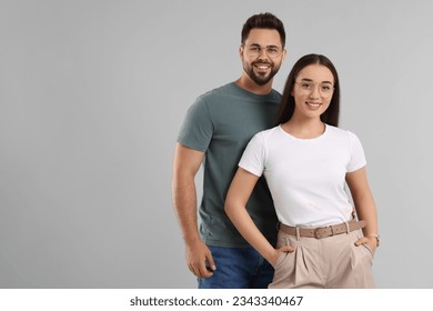 Beautiful couple wearing glasses on light gray background, space for text - Powered by Shutterstock