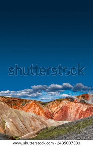 Beautiful cover page with copy space of Icelandic landscape of colorful rainbow volcanic Landmannalaugar mountains, at famous Laugavegur hiking trail with blue sky, and red volcano soil in Iceland