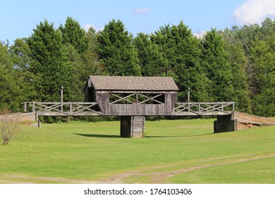 a beautiful covered bridge over an empty green meadow crossing