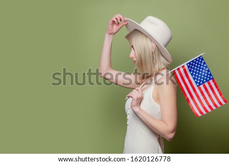 Beautiful cowgirl in a hat with United States of America flag