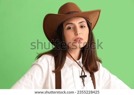 Beautiful cowgirl on green background, closeup