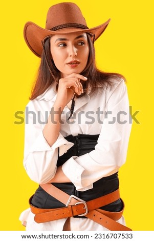 Beautiful cowgirl on yellow background