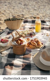 Beautiful cozy summer picnic with lemonade, fresh bread and fruits on a beach at sunset.
