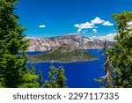 Beautiful Crater Lake National Park with late season snow still lingering into early summer. Bright blue lake with reflections