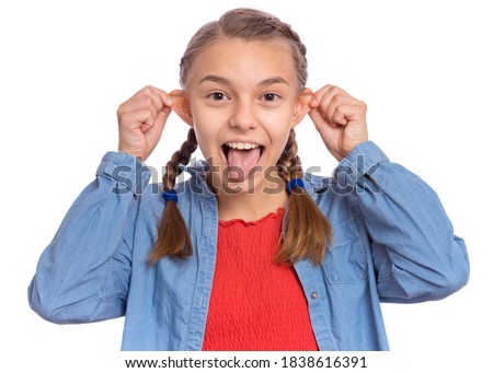 Beautiful crazy teenage girl makes funny face and sticks out tongue, plays fool, being in good mood, isolated on white background