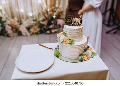 A Beautiful Creamy White Cake, Decorated With Flowers, With A Sign Mistrette And Mrs. Stands On A Wooden Table, Covered With A Tablecloth. Wedding Food Photography.