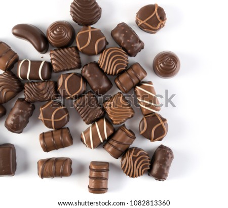 Beautiful Creative Chocolate Sweets Isolated on White Background. Scattered Chocolates Top View and Flat Lay