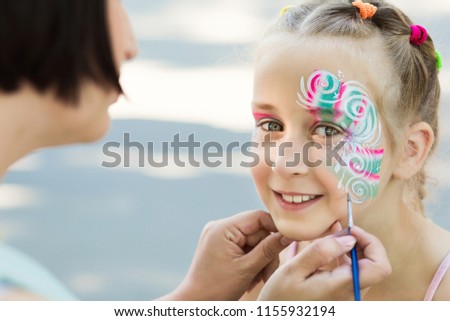 Beautiful creative pattern on happy little girl, children face painting, copy space