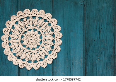 Beautiful crochet doily on blue wooden background