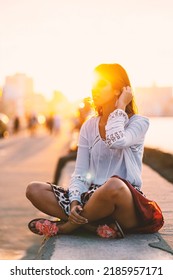 Beautiful Cuban Woman Portrait On The Malecon. Havana, Cuba. Real Life Style Image At Sunsetwith Flare.