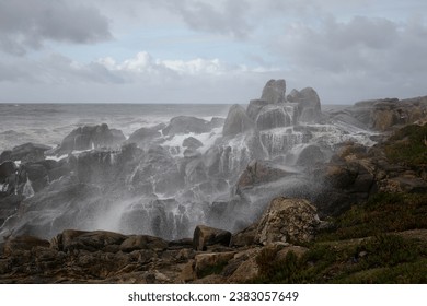 Beautiful and curious seascape seeing the northern rocky coast of Portugal covered with spray of a stormy wave that had just hit the cliffs - Powered by Shutterstock