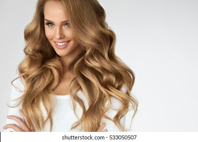 Beautiful Curly Hair. Smiling Girl With Healthy Wavy Long Blonde Hair. Portrait Happy Woman With Beauty Face, Sexy Makeup And Perfect Hair Curls. Volume, Hairstyle, Hairdressing Concept. High Quality