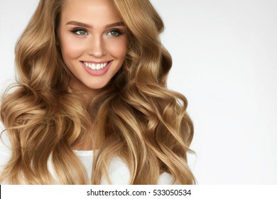 Beautiful Curly Hair. Smiling Girl With Healthy Wavy Long Blonde Hair. Portrait Happy Woman With Beauty Face, Sexy Makeup And Perfect Hair Curls. Volume, Hairstyle, Hairdressing Concept. High Quality