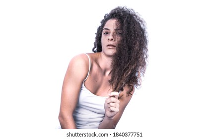 Beautiful Curly Haired Female Model Posing In Studio Holding Her Hair. Isolated On White