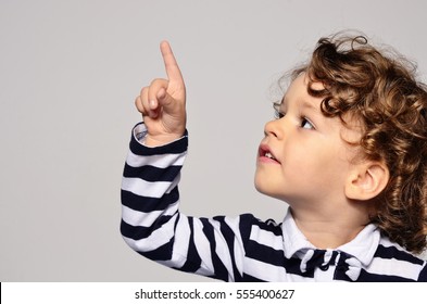 Beautiful Curly Toddler Looking Up. Boy Showing, Kid Holding His Hand Up