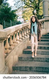 Beautiful Curly-haired Hispanic Woman Walking Down An Old Staircase From The Early 20th Century In The City.