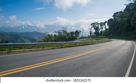 Beautiful Curve Asphalt Road On The Green Mountain With More Clouds On Mountain And Blue Sky Background , Road In Northern Of Thailand