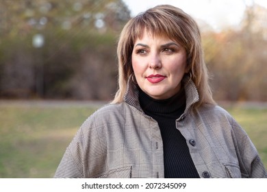 A beautiful curvy mature woman looks to the side. Female portrait of middle-aged person outdoors - Shutterstock ID 2072345099