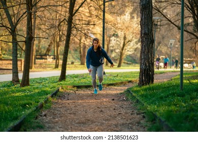 A Beautiful Curvy Woman Runs In A Nature Park At Sunset.