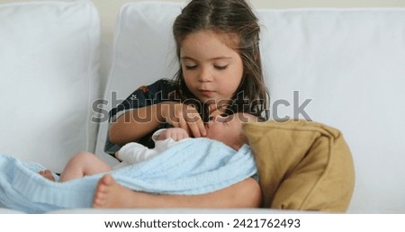 Beautiful cute family moment sister kissing newborn baby brother