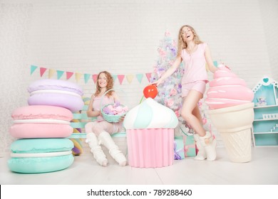 beautiful cute girls friends with giant yummy cake, macaroons and ice-cream on white background