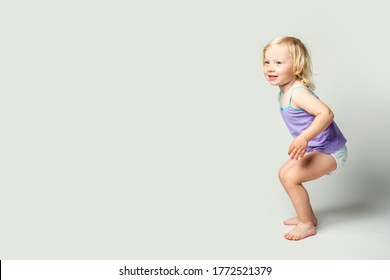 Beautiful cute little baby smiles, dances, imagines on a white background