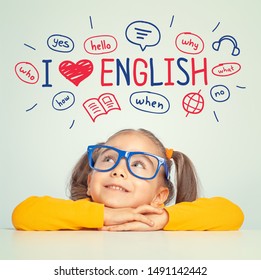 Beautiful cute little girl with eyeglasses looking at the illustrations and words in english above her head. I love english concept. - Shutterstock ID 1491142442