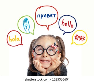 Beautiful Cute Little Girl With Eyeglasses Looking At Hello Word In Spanish, English, Russian, Chinese And American Sign Language In Speech Balloons. K-12 Foreign Language Learning Concept.