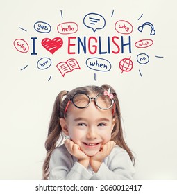 Schönes süßes kleines Mädchen mit Brillen lächeln, während Illustrationen und Wörter in Englisch über ihrem Kopf. Konzept des Fremdsprachenlernens Ich liebe Englisch. 